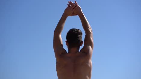 Nackter-Oberkörper,-Muskulöser-Mann,-Der-Die-Arme-Gegen-Den-Blauen-Himmel-Ausstreckt